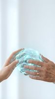 Two hands holding glowing digital globe with network connections, representing global communication, technology partnership, and worldwide business collaboration.