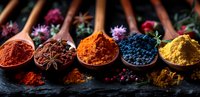 Vibrant colorful spices and seasonings in wooden spoons arranged on dark stone background, perfect for cooking, food blog, or restaurant menu design. Includes paprika, turmeric, and exotic spice blend