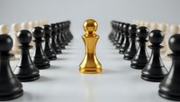 Golden chess king piece standing out among black pawns in strategic leadership and business success concept for corporate hierarchy and teamwork.
