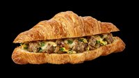Flaky croissant breakfast sandwich with sausage and scrambled eggs, isolated on transparent background, ready for menu design, food clipart, stickers, and print on demand.