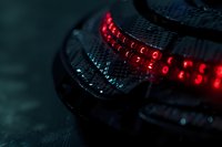 Red LED lights glowing in dark macro shot with selective focus, creating futuristic technological atmosphere for backgrounds and tech concepts.