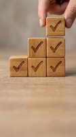 Hand placing wooden block with checkmark onto pyramid stack of blocks with check marks, representing success, quality assurance, task completion, and business growth for corporate projects.