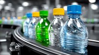 Colorful plastic bottles on conveyor belt in beverage factory production line. Selective focus on transparent and colored water bottles in manufacturing process.