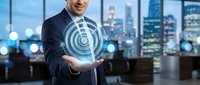 Professional businessman presenting digital target hologram in modern office with city skyline background for business strategy and goal achievement concepts.