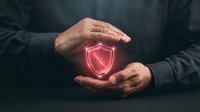 Hands protecting glowing red shield icon symbolizing cybersecurity, data protection, and digital safety for business and technology concepts.