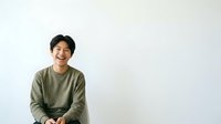 Young Asian man with dark hair wearing olive green long-sleeve shirt, smiling at camera against white background. Portrait for advertising, lifestyle, and corporate projects.