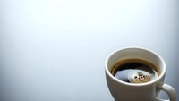 White coffee mug with hot black coffee on clean background with copy space for morning beverage concepts and cafe marketing materials.