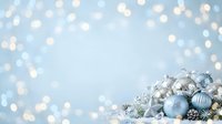 Festive silver and blue ornaments with decorative accents arranged on snow against soft bokeh background, suitable for holiday greeting cards and seasonal marketing materials.
