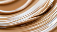 Smooth flowing copper wire cables creating elegant curved lines with metallic shine and warm bronze tones for technology and electrical concepts.