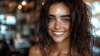 Young woman with wet dark hair and bright smile against blurred bokeh background, natural glowing skin and white teeth, radiating happiness and joy.