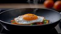 Steaming sunny side up egg with black pepper served on bed of fresh vegetables in dark plate, morning breakfast food photography with steam rising.