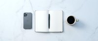 Modern workspace flat lay with smartphone, open notebook with pen and coffee cup on white marble surface for business productivity and planning.