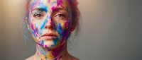 Young Caucasian woman with vibrant multicolored paint covering face and body in artistic expression of creativity and self-expression against neutral background.