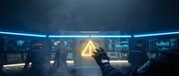 Futuristic control room with glowing holographic interface and robotic hand reaching toward illuminated pyramid symbol on advanced technology dashboard.