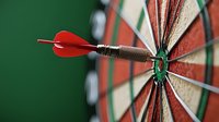 Red dart hitting bullseye on professional dartboard, extreme close-up macro shot showing precision and accuracy against green background. Success concept for business goals.