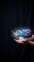 Hands holding glowing digital technology with blue and orange light waves, circuit patterns, and data symbols on dark background for innovation and tech concepts.