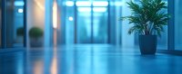 Empty modern office hallway with blue ambient lighting, reflective floor, decorative palm plant, and glass walls creating minimalist corporate atmosphere.