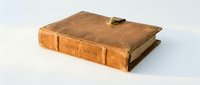 Antique leather-bound archive book with worn tan cover and brass clasp, isolated on white background for design, publishing, library, and historical projects.