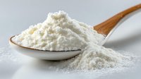 Fine white flour or baking powder on wooden spoon against neutral gray background, highlighting texture and purity for cooking and baking applications.