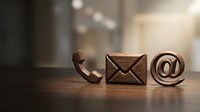 Wooden contact icons phone envelope email symbol on desk representing communication methods for business customer service and digital correspondence.
