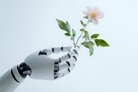 White robotic hand gently holding delicate pink flower with green leaves against light background, representing artificial intelligence and nature harmony.