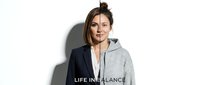 Young woman showing work life balance concept with half business suit half casual hoodie on white background for lifestyle and career design projects.