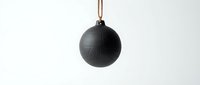 Black spherical pendant light with copper cord hanging against white background, modern minimalist lighting fixture for interior design.
