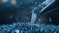 Cascading blue crystals falling from glass container with bokeh effect and dark background, creating dramatic macro photography composition for luxury product ads.