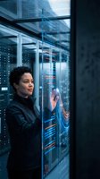 African American woman data scientist working with holographic interface in modern server room analyzing digital information and technology systems.