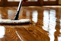 Microfiber mop cleaning polished hardwood floor in bright home interior. Professional housekeeping and maintenance concept for residential spaces.