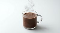 Hot chocolate drink in clear glass mug with steam rising on white background. Warm cocoa beverage for winter comfort and cozy moments.