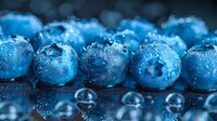 Fresh ripe blueberries covered with water drops on dark background, macro shot showing juicy texture and natural moisture for food photography.