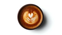 Creamy latte art featuring heart-shaped rosetta pattern in rich brown coffee against white milk foam, served in dark ceramic cup on white background, isolated view.