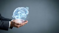 Businessman hand holding glowing digital brain hologram representing artificial intelligence, machine learning and cognitive technology solutions.