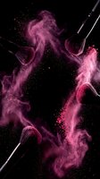 Makeup brushes with vibrant pink powder explosion on black background creating dynamic beauty and cosmetics concept for professional use.
