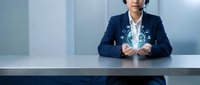 Professional businesswoman in navy suit presenting digital technology interface with holographic icons at modern office desk for corporate presentations.