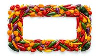 Colorful fresh chili peppers and bell peppers arranged in rectangular frame border on white background with empty space for text or product placement.