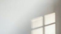 Soft window light casting geometric shadows on neutral wall surface, creating minimalist interior ambiance for design and background use.