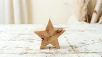 Wooden star decoration on rustic white table surface for home decor and craft projects.
