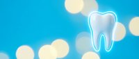 Clean white tooth with protective shield on bright blue background with golden bokeh lights for dental care and oral health concepts.