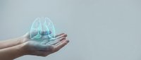 Hands holding glowing holographic lungs projection representing respiratory health, medical technology, healthcare innovation and pulmonary system awareness.