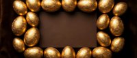 Golden eggs arranged in rectangular frame on brown background creating elegant border for Easter holiday celebrations and luxury design projects.