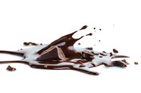 Melted dark chocolate pieces with liquid splash and scattered chunks on white background, isolated food photography for confectionery and dessert designs.