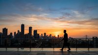Silhouette of man jogging on rooftop terrace overlooking urban skyline at golden hour sunset, fitness and wellness lifestyle concept for health and exercise backgrounds.