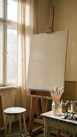 Artist studio with blank canvas on wooden easel, paintbrushes and art supplies on rustic table, warm natural light streaming through window for creative workspace.