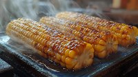Grilled corn on the cob with steam rising, showing golden kernels with char marks on dark stone surface, creating appetizing street food atmosphere.