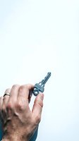 Male hand with wedding ring holding a silver house key against a white background, symbolizing real estate, home ownership, and new beginnings.