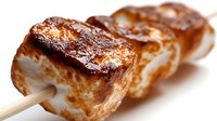 Grilled pork belly skewers with caramelized surface on wooden sticks, ready for barbecue and outdoor cooking events.