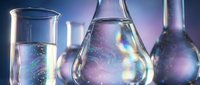 Laboratory glassware with colorful iridescent liquid solutions in beakers and flasks for scientific research and chemical experiments.