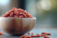Wooden bowl filled with red kidney beans on kitchen counter with scattered beans around for healthy cooking and nutrition concepts.